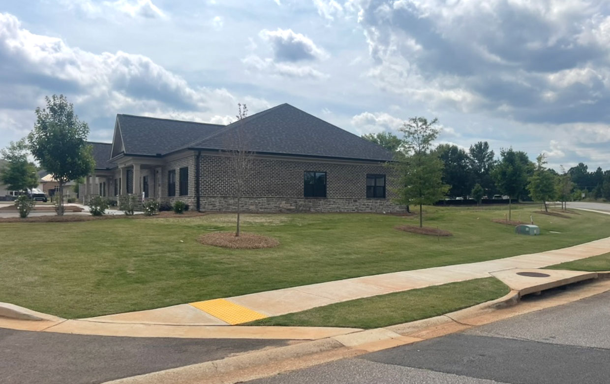 The Seed Orchard building — a brick-and-stone office with a landscaped lawn and young trees, Radiant Orchard's first dedicated home.