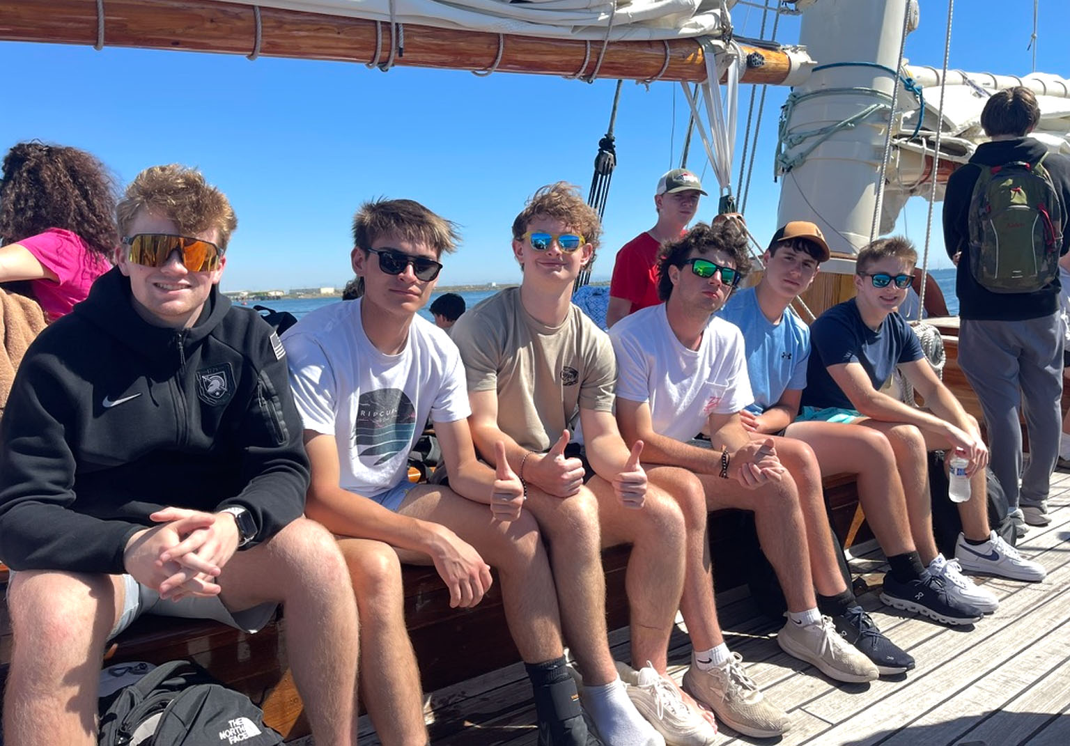 A group of young men on the deck of a sailing ship on a bright day — a shared journey worth remembering.